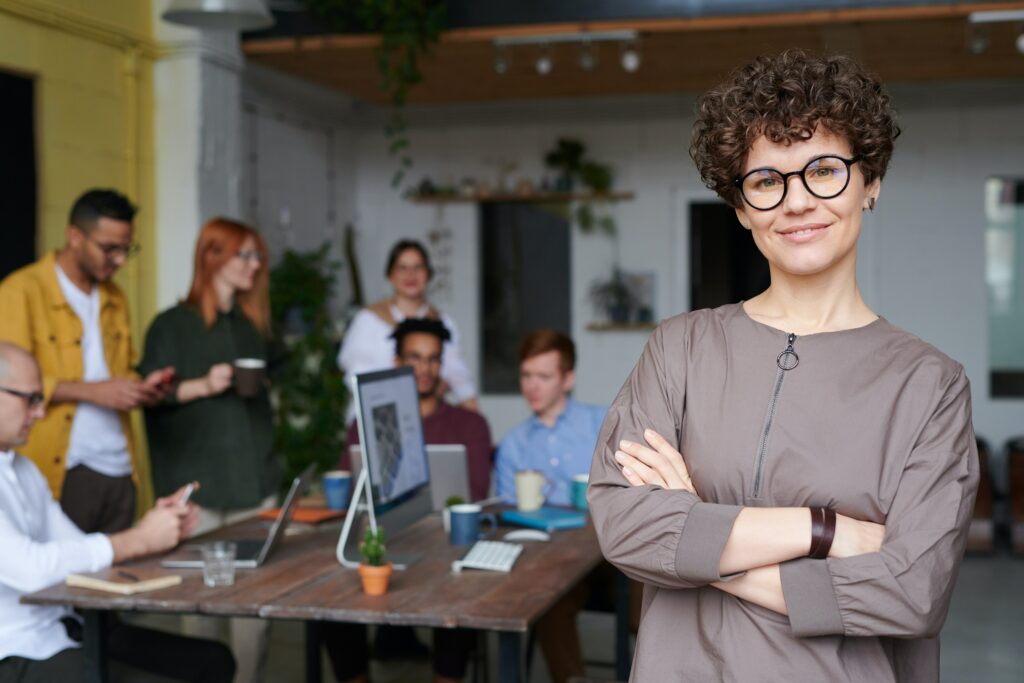 Mulher líder em frente a uma equipa de trabalho faz uma gestão de conflitos eficaz.