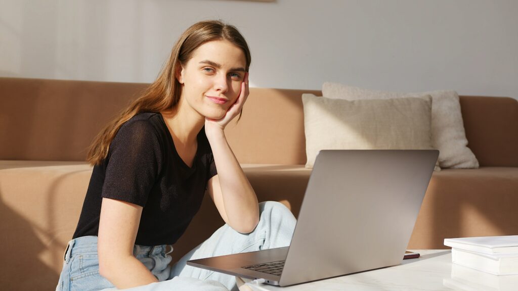mulher jovem, que usa a inteligência emocional para ser mais disciplinada, está em frente a um laptop.