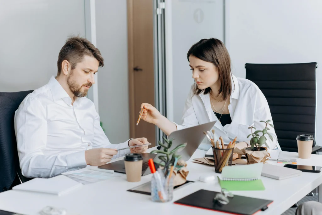 Homem e mulher, sentados à secretária num escritório, identificam a importância do autoconhecimento para uma relação profissional forte e saudável.